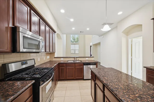 a kitchen with stainless steel appliances granite countertop a stove and a sink