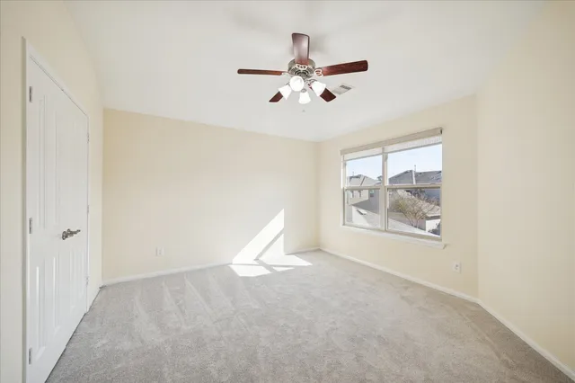 a view of a room with a ceiling fan and window