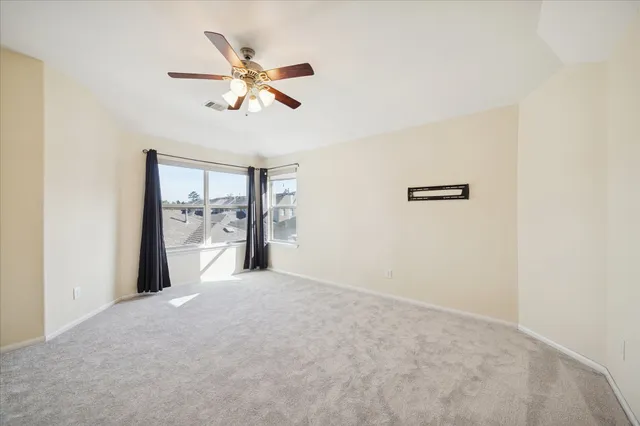 a view of a livingroom with a ceiling fan and window