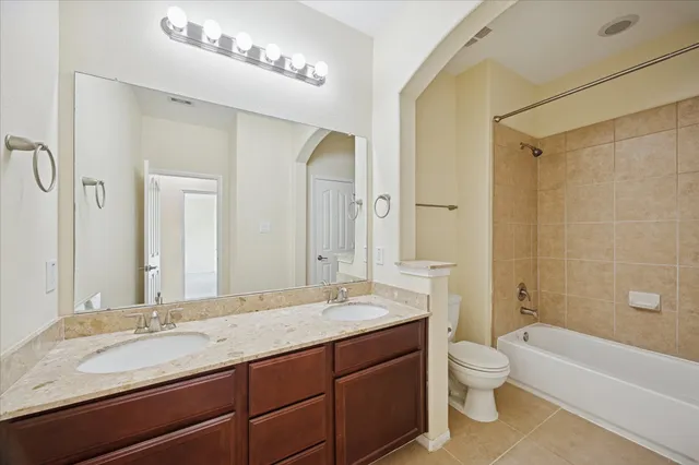 a bathroom with a granite countertop sink toilet mirror and bathtub