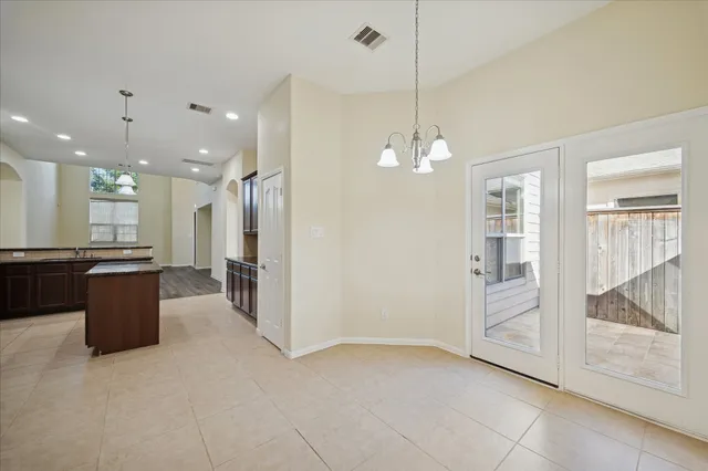 a view of a big room with a chandelier fan and windows