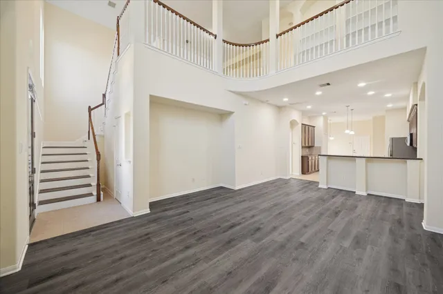 a view of a hallway with wooden floor and a kitchen