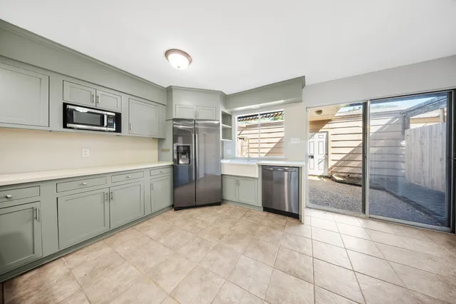 a kitchen with granite countertop a refrigerator and a stove top oven