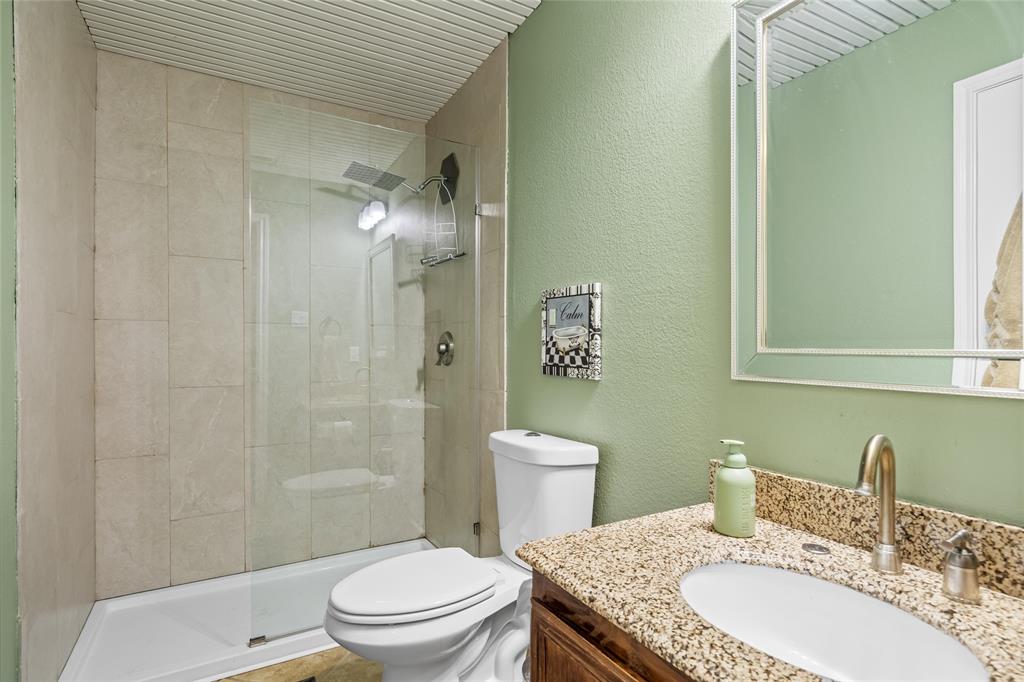 1901 Yellowstone Lane Corinth, TX 76210 - Photo 13 of 32 Bathroom with vanity, a shower stall, and a textured wall