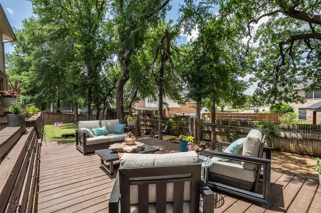 a view of a patio with couches potted plants and large tree