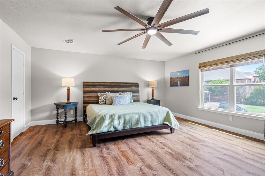 1901 Yellowstone Lane Corinth, TX 76210 - Photo 28 of 32 Bedroom featuring wood finished floors, a ceiling fan, and a textured ceiling