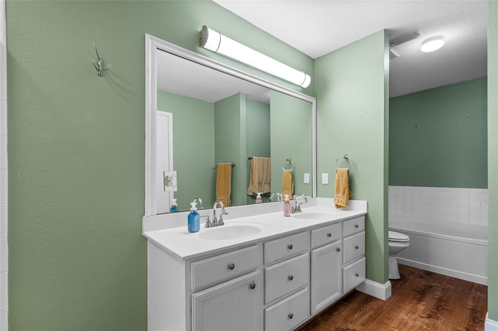 1901 Yellowstone Lane Corinth, TX 76210 - Photo 30 of 32 Full bath with dark wood-type flooring, a bath, and double vanity