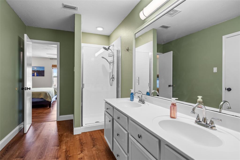 1901 Yellowstone Lane Corinth, TX 76210 - Photo 31 of 32 Ensuite bathroom featuring dark wood finished floors, a shower stall, and double vanity