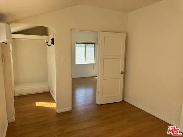an empty room with wooden floor and a window
