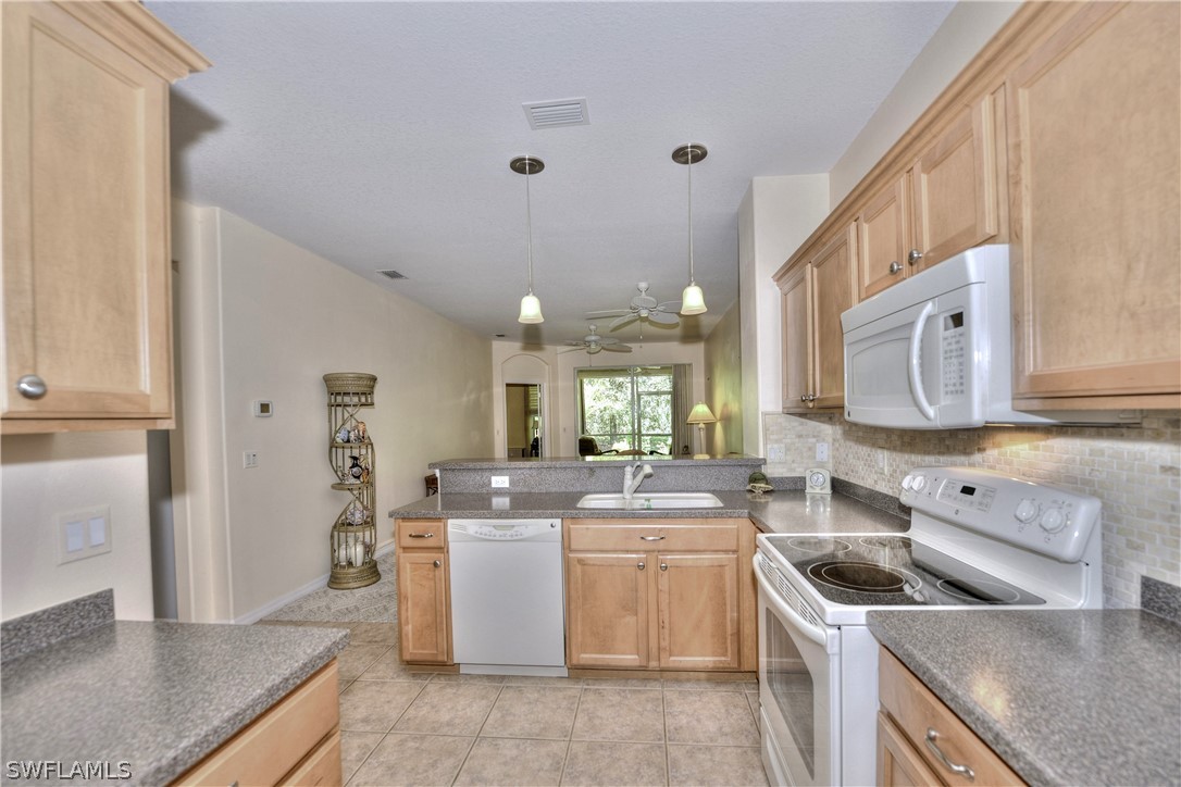 3600 Rue Alec Loop, Unit 5 North Fort Myers, FL 33917 - Photo 10 of 16 a kitchen with a sink stove top oven and cabinets