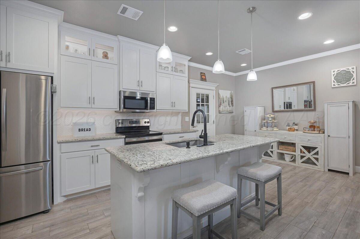 39 Cm Lane Canyon, TX 79015 - Photo 7 of 26 a kitchen with stainless steel appliances granite countertop a refrigerator a stove a sink a dining table and chairs with wooden floor