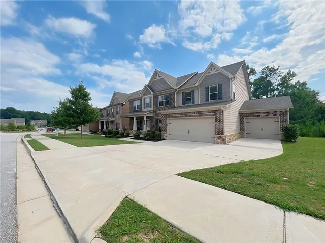 a front view of a house with a garden and yard
