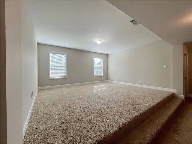 a view of an empty room with a chandelier fan