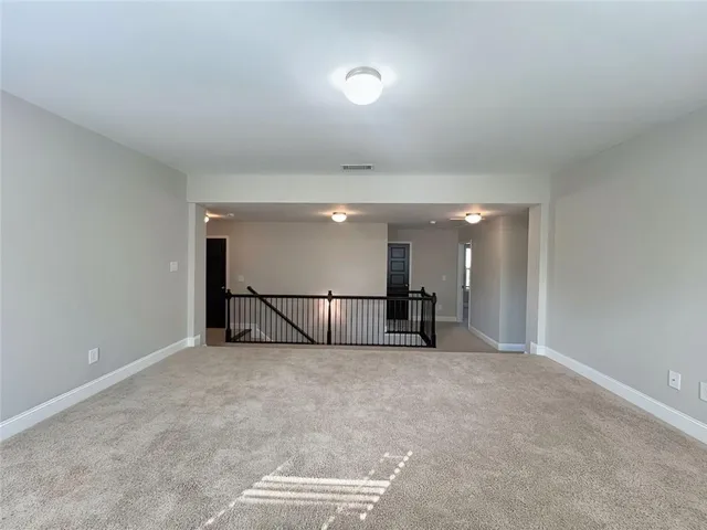 a view of an empty room with closet and a ceiling fan