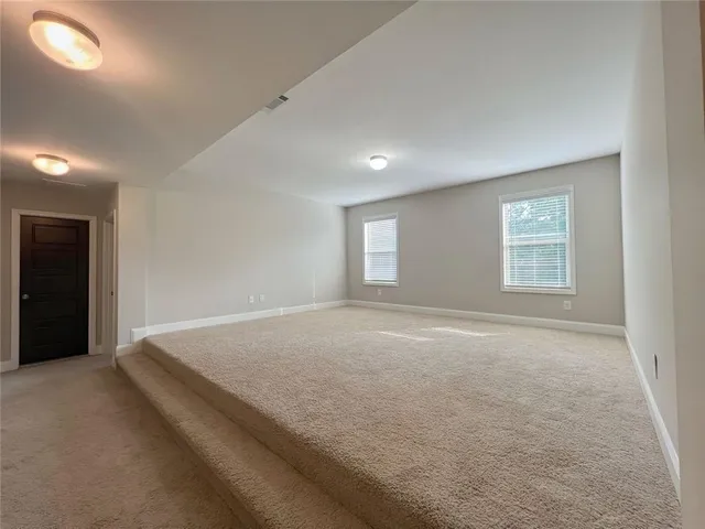 a spacious bathroom with a granite countertop double vanity sink a mirror and a bathtub