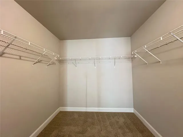 an empty room with closet and windows
