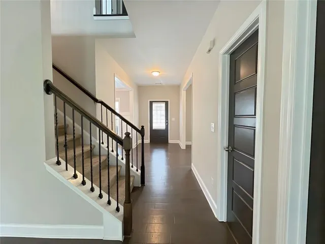 an empty room with wooden floor chandelier and windows