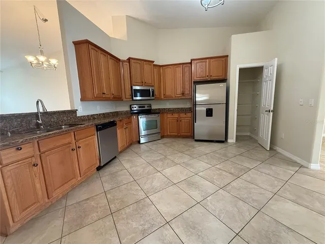 a kitchen with stainless steel appliances granite countertop a sink refrigerator and cabinets