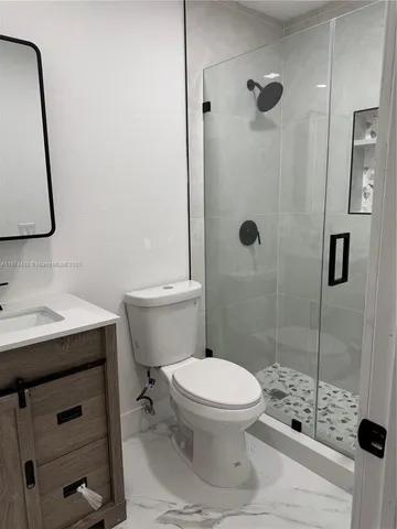 a bathroom with a sink a toilet a mirror and shower