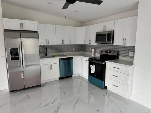 a kitchen with stainless steel appliances and white cabinets