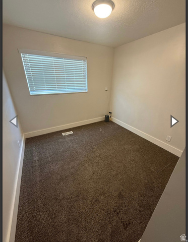 106 East Richelman Lane Wellington, UT 84542 - Photo 14 of 35 Unfurnished room featuring dark carpet and a textured ceiling