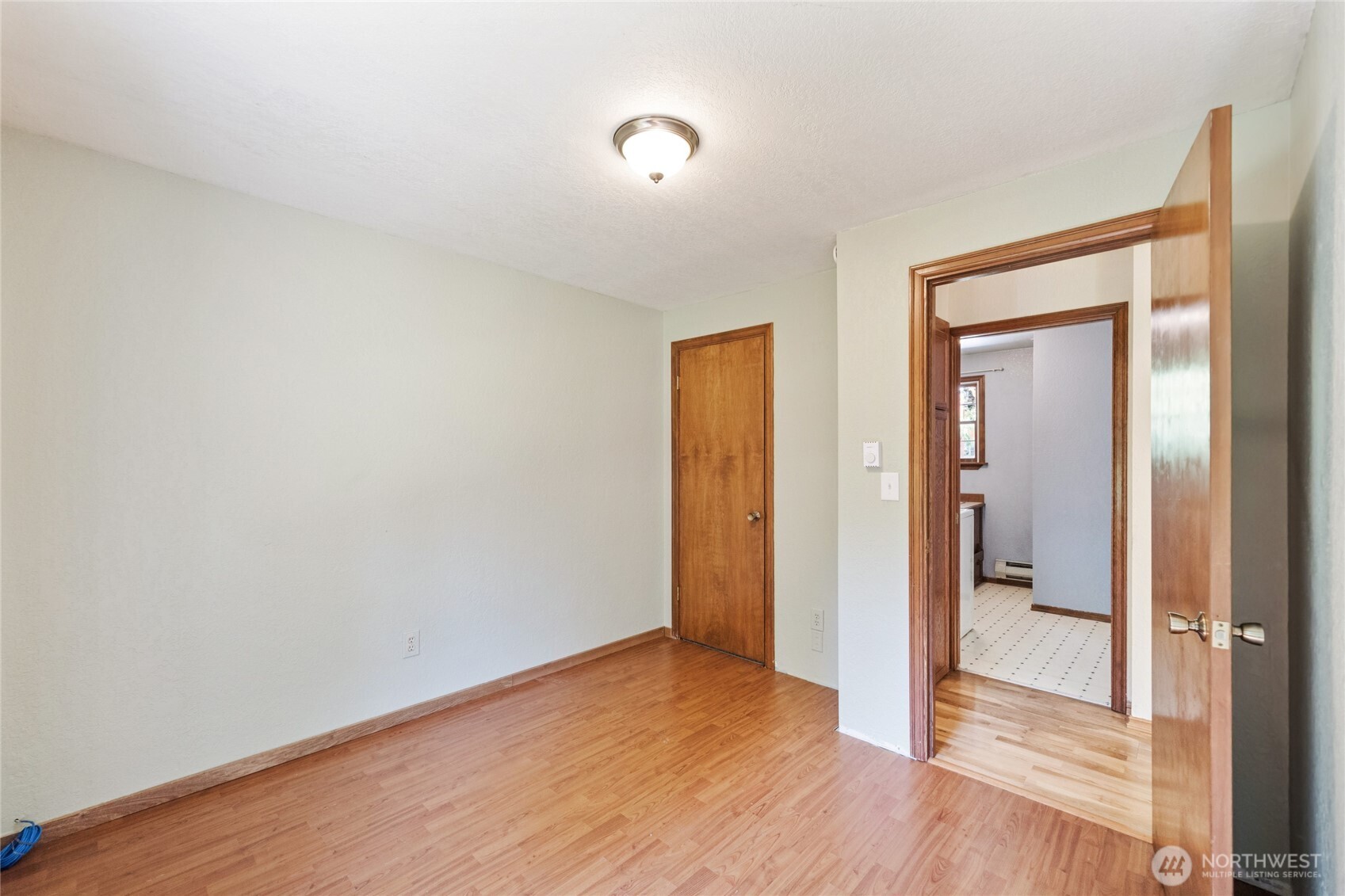2216 Newberg Road Snohomish, WA 98290 - Photo 14 of 32 a view of an empty room with wooden floor and a bathroom