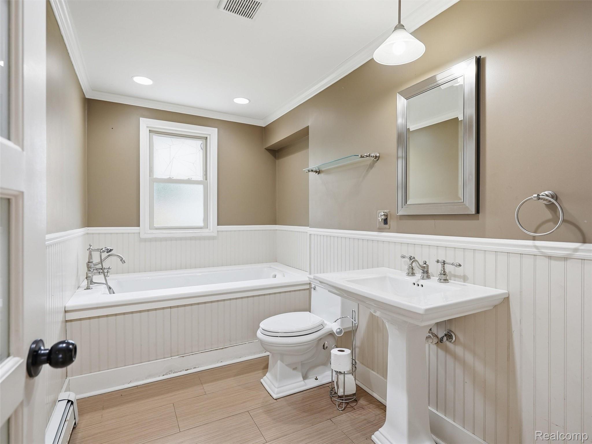 117 Kenyon Road Algonac, MI 48001 - Photo 22 of 47 Bathroom featuring a pedestal sink, white paneled wainscoting, an integrated bathtub with a chrome faucet, recessed lighting, and wood-look flooring