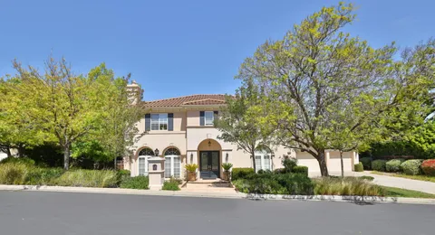 a front view of a house with a yard and fountain