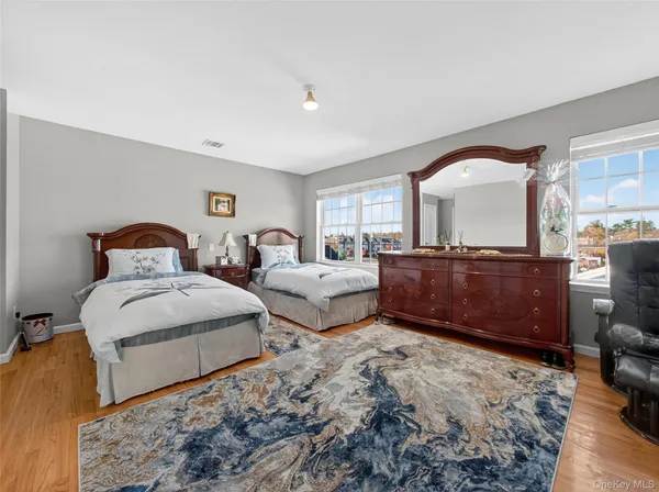 a large bedroom with a bed a large window and dresser