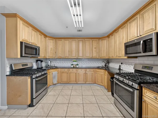 a kitchen with stainless steel appliances granite countertop a stove sink microwave and cabinets