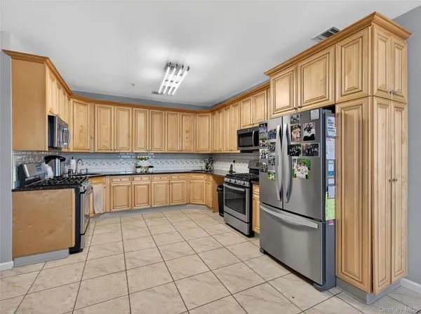a kitchen with stainless steel appliances granite countertop a refrigerator and a stove top oven