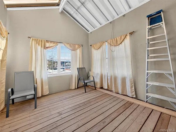 a view of a room with wooden floor and furniture