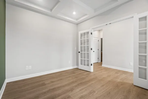 an empty room with wooden floor and white walls