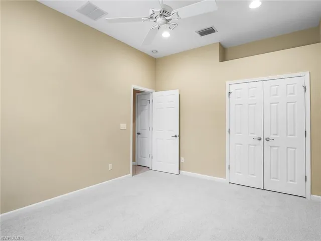 a view of an empty room and chandelier fan