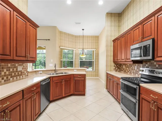 a kitchen with stainless steel appliances granite countertop wooden cabinets a stove top oven a sink and dishwasher
