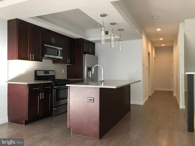 an empty room with wooden floor and cabinet