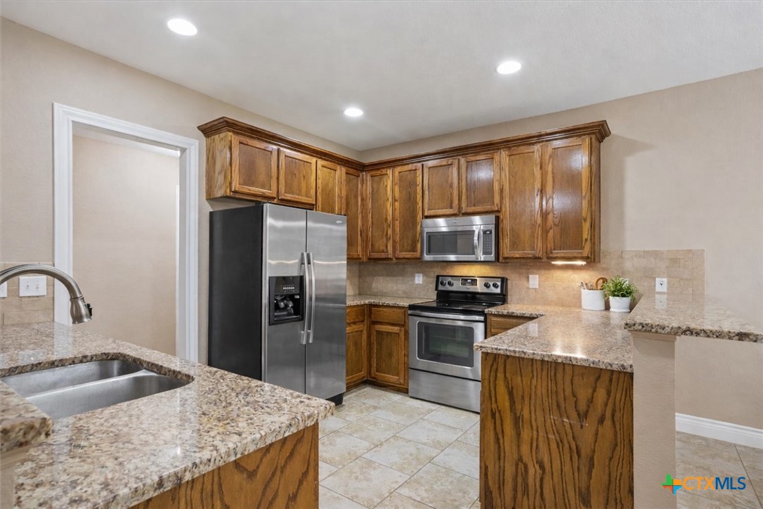 198 Sheridan Loop Belton, TX 76513 - Photo 14 of 31 a kitchen with granite countertop a sink stainless steel appliances and cabinets