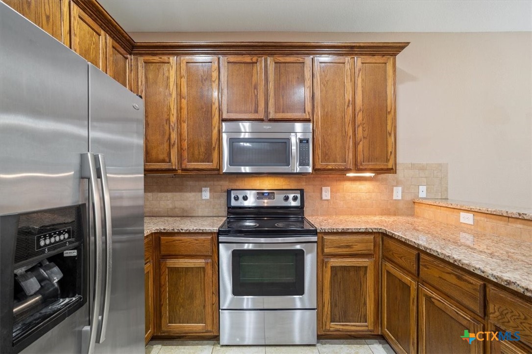 198 Sheridan Loop Belton, TX 76513 - Photo 15 of 31 a kitchen with stainless steel appliances granite countertop a stove and a refrigerator
