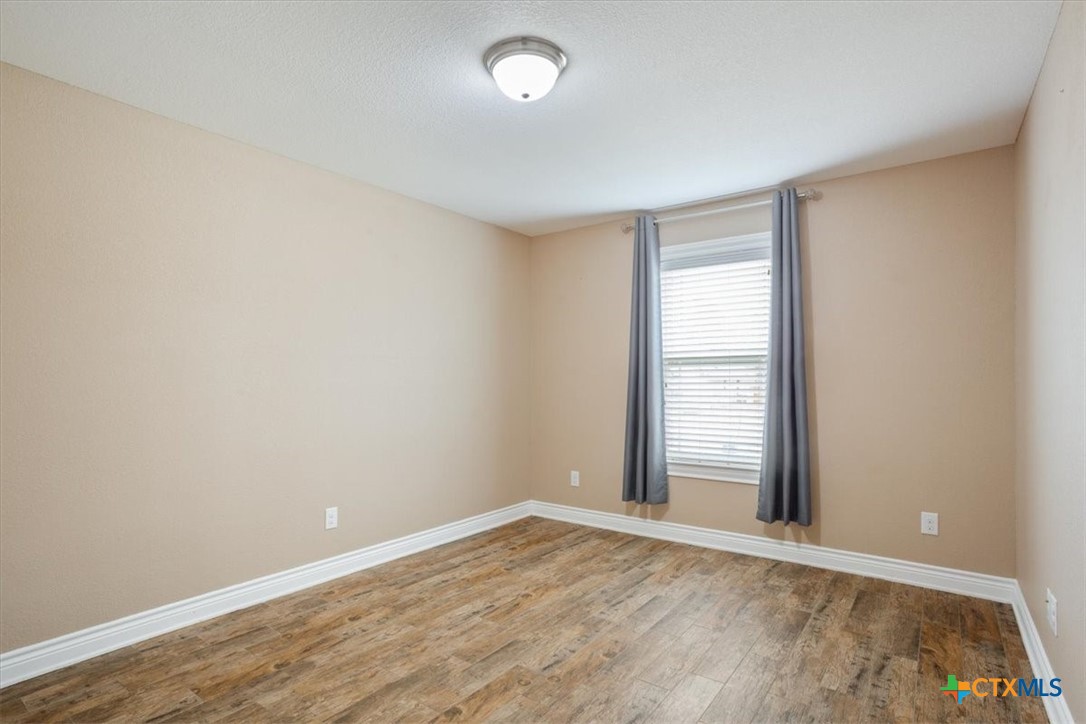 198 Sheridan Loop Belton, TX 76513 - Photo 24 of 31 wooden floor in an empty room with a window