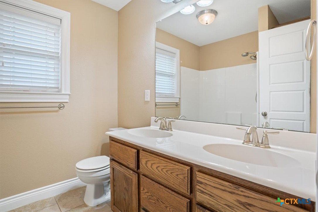 198 Sheridan Loop Belton, TX 76513 - Photo 25 of 31 a bathroom with a granite countertop sink toilet and mirror