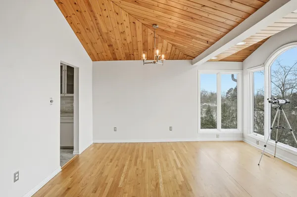 a view of empty room with wooden floor and fireplace