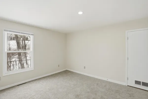 a view of an empty room with stairs and a fireplace