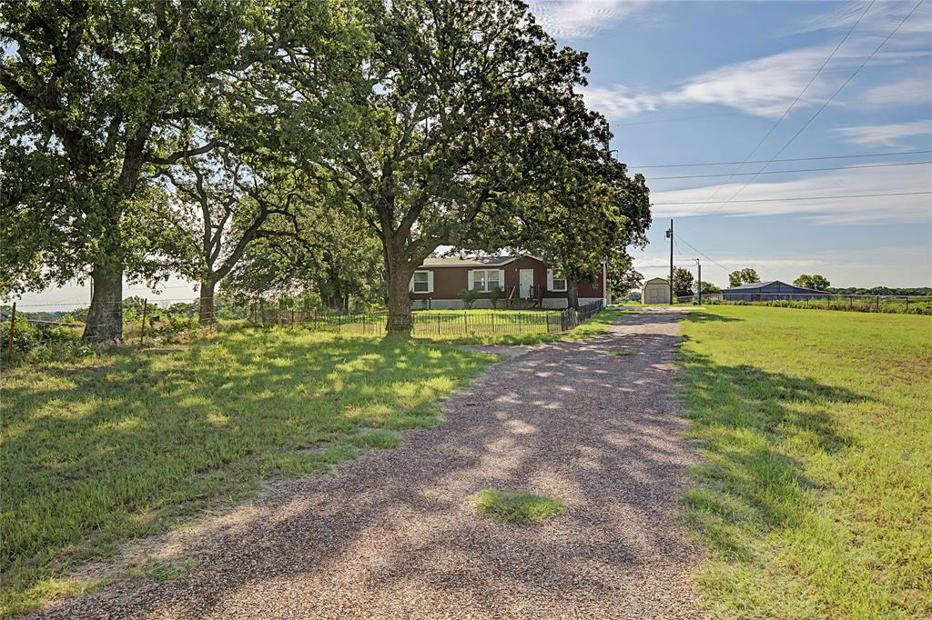 177 New Highland Road Springtown, TX 76082 - Photo 39 of 40 Expansive gravel driveway leading to a single-story residence