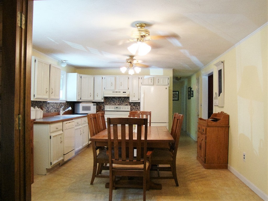 63 Pierpont Road Dudley, MA 01571 - Photo 6 of 21 a kitchen with a dining table chairs and refrigerator