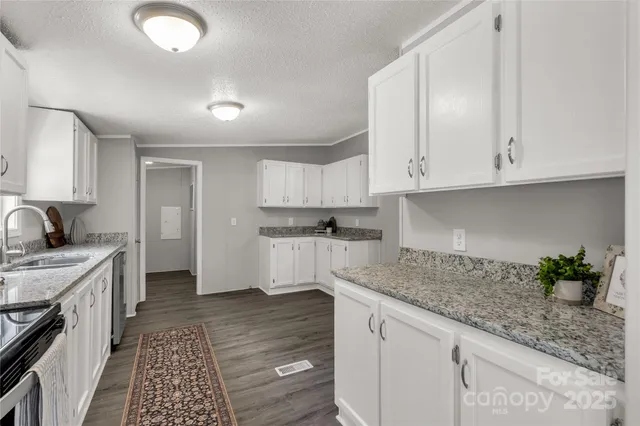 a kitchen with granite countertop a sink stainless steel appliances and cabinets