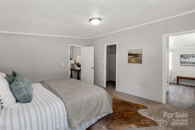 a bedroom with a large bed and wooden floor
