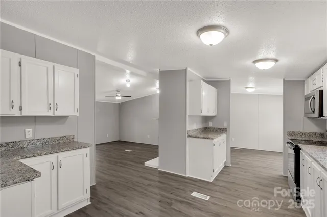 a kitchen with granite countertop a sink and a stove top oven