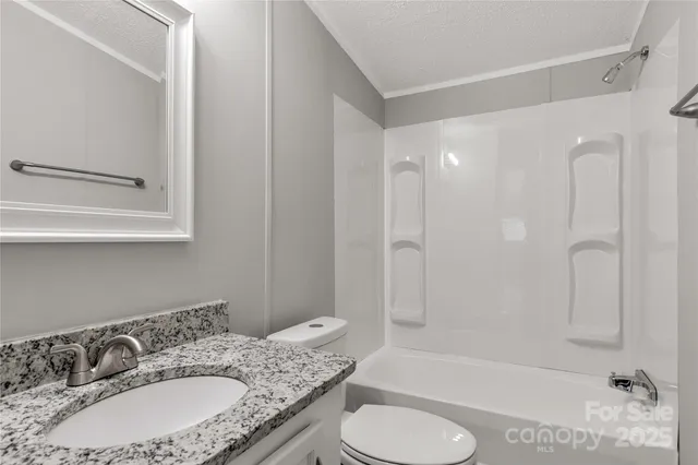 a bathroom with a granite countertop sink toilet tub and shower