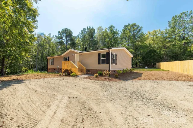a view of a house with backyard and trees