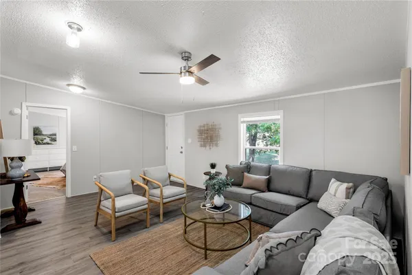 a living room with furniture ceiling fan and a window
